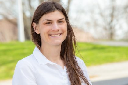 A photo of Julie McCabe smiling on a residential street