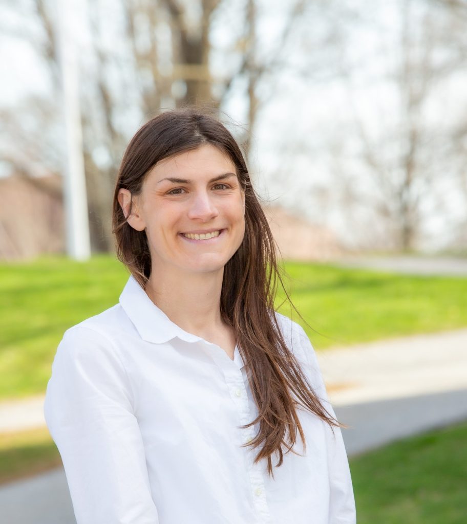 A photo of Julie McCabe smiling on a residential street