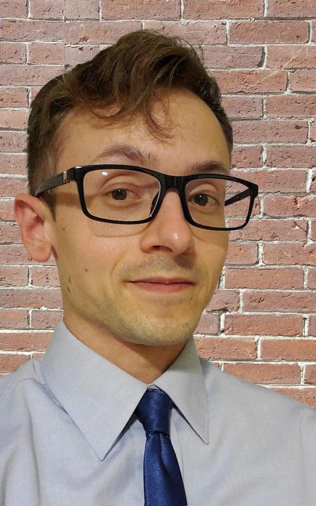 Head shot of Luke Jensen, candidate for Maine House District 96. He is smiling and wearing glasses