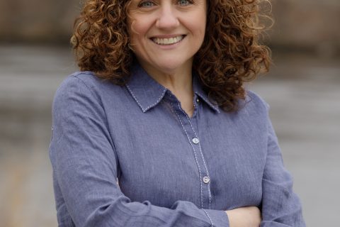 A photo of a smiling Pamela Hart who has curly red hair