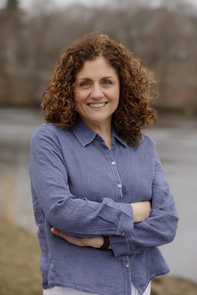 A photo of a smiling Pamela Hart who has curly red hair